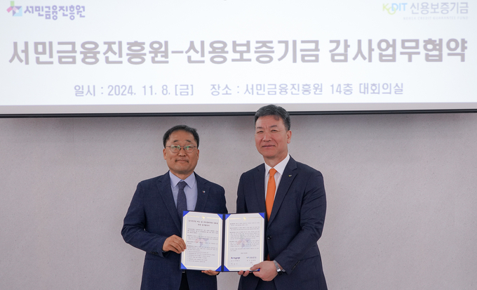 민좌홍 신용보증기금 상임감사(오른쪽)와 백맹기 서민금융진흥원 상임감사가 지난 8일 서민금융진흥원 본점에서 열린 ‘감사전문성 제고 및 내 부통제역량 강화를 위한 업무협약식’에서 협약서에 서명한 뒤 기념촬영을 하고 있다. (사진=신보 제공)