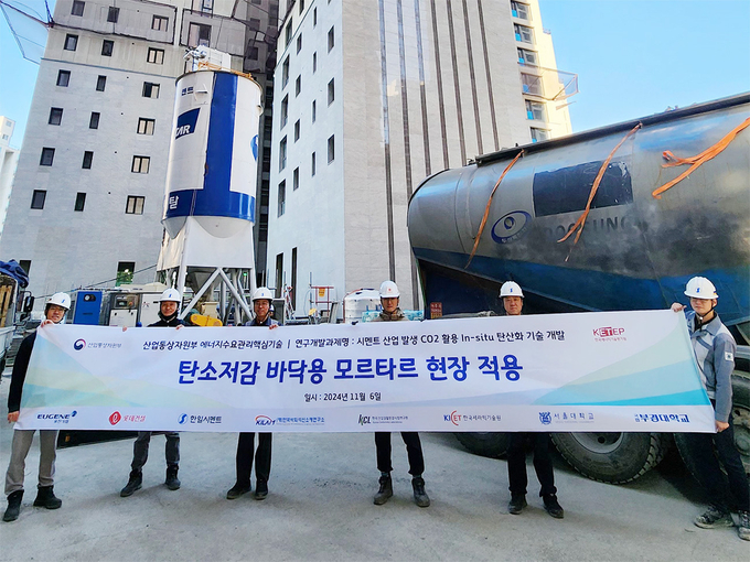 롯데건설이 지난 6일 한일시멘트와 함께 개발한 ‘CO₂(이산화탄소) 주입 바닥용 모르타르’ 기술을 현장에 적용하고 기념사진을 촬영하고 있다. (사진=롯데건설 제공)