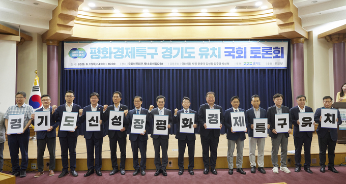 김동연 경기도지사와 국회의원들이 지난해 8월 17일 평화경제특구 경기도 유치 국회 토론회에서 카드섹션을 하며 기념촬영을 하고 있다.