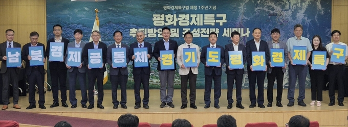 지난 7월 19일 오전 국회 의원회관에서 열린 ‘평화경제특구법 제정 1주년 기념 평화경제특구 추진방안 및 조성전략 세미나’ 참석자들이 팻말을 들고 기념사진을 찍고 있다. (사진=김한별 기자)