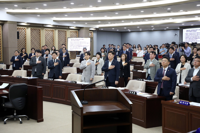 지난 6월 11일 수원시의회 제382회 제1차 정례회 본회의에서 수원시의회 의원들과 수원시 관계자들이 참석해 국민의례를 하고 있다. (사진=수원시의회 제공)