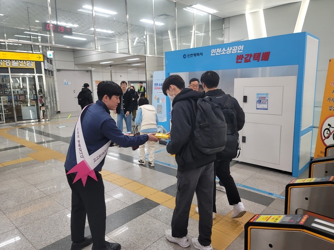 인천2호선 가정중앙시장역 개찰구에서 인천교통공사 직원이 수험생에게 핫팩과 화장지를 나눠주고 있다. ( 사진 = 인천교통공사 제공 )