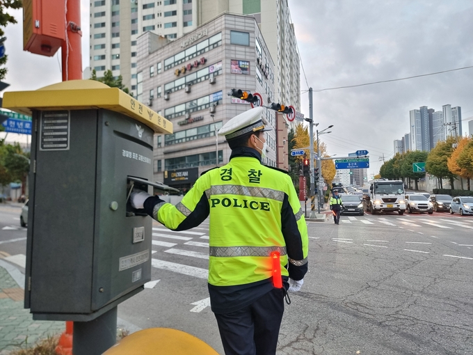경찰이 교통신호제어기를 조정하고 있다. ( 사진 = 김민지 기자 )