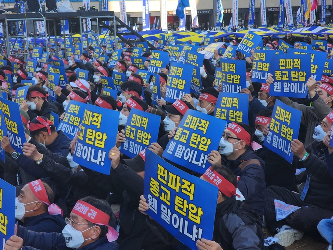  15일 경기도청 앞에서 진행된 신천지 집회에 참여한 신도들이 피켓을 들고 있다. (사진=박진석 기자)