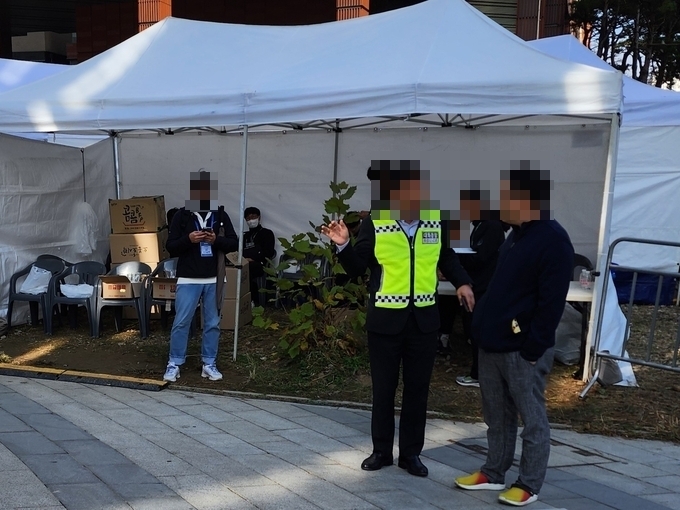  15일 경기도청 앞에서 진행된 신천지 집회에 항의한 주민 D씨(오른쪽)과 그의 사진을 찍은 신천지 측 관계자(왼쪽). (사진=박진석 기자)