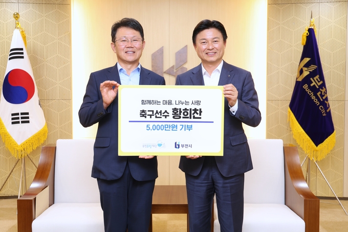 황희찬 선수 아버지 황원경 씨(왼쪽)가 조용익 부천시장에게 기부금을 전달하고 있다. (사진=부천시 제공)