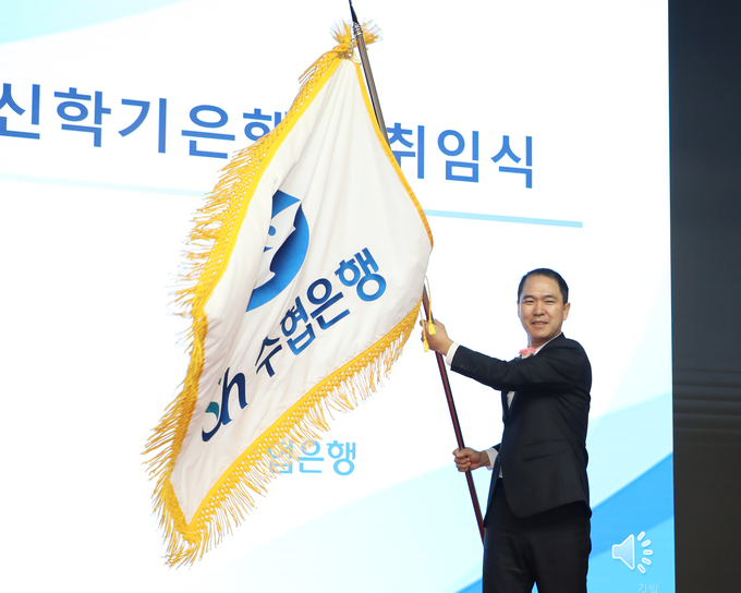 신학기 신임 수협은행장이 18일, 서울 송파구 수협은행 본사에서 진행된 취임식에서 수협은행기를 흔들고 있다. (사진=Sh수협은행 제공)