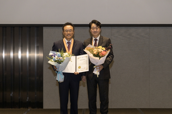 고려대학교 선우명호 석좌교수(왼쪽)와 한국자동차공학회 전병욱 회장이 기념사진을 촬영하고 있다. (사진=한국자동차공학회 제공)