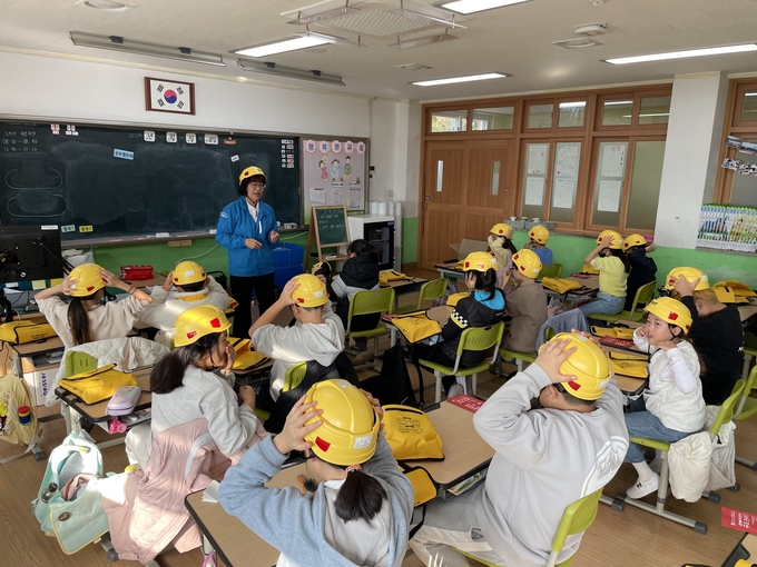 울진 죽변초등학교에서 ‘재난안전 경안전모 전달식 및 재난안전교육’ 행사를 진행하고 있는 모습. (사진=현대건설 제공)