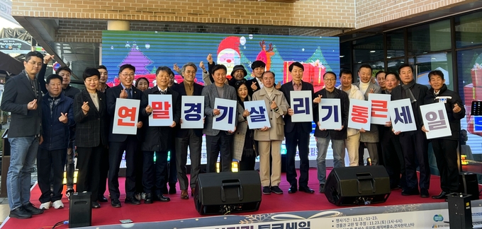지난 23일 오후 부천상동시장 일대에서 열린 ‘연말 경기 살리기 통큰 세일’ 행사에서 조용익 부천시장, 김병전 부천시의장, 서영석·김기표 국회의원, 이재영 경기도의원, 김민철 경상원장 등 참석자들이 기념촬영을 하고 있다. (사진=경상원 제공)