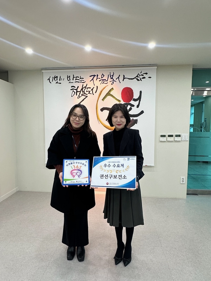 수원시 권선구보건소와 수원시자원봉사센터 관계자들이 현판 전달 후 기념 촬영을 하고 있다. (사진=수원시 제공)