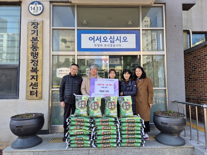 김포장기본동 앞에서 쌀 나눔행사를 준비한 하늘꿈 교회 성도와 주이자 동장이 기념사진을 찍고 있다. (사진=김포시 장기본동 제공)