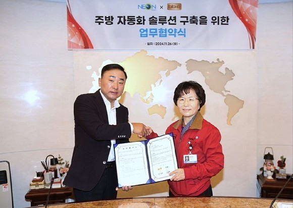 BBQ가 자동화 장비 개발 전문 업체인 네온테크와 손잡고 스마트 주방 시스템 구축을 위한 업무협약을 체결했다. 윤경주 제너시스BBQ 그룹 부회장(오른쪽), 황성일 네온테크 대표이사. (사진=제너시스BBQ 제공)