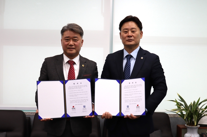 27일 오전 경기도의회에서 최종현(수원7·오른쪽) 경기도의회 더불어민주당 대표의원과 김정호(광명1) 경기도의회 국민의힘 대표의원이 합의문을 들고 기념촬영을 하고 있다. (사진=경기도의회 제공)