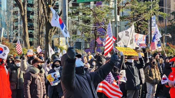  28일 서울 세종대로에서 진행된 윤석열 대통령 탄핵 반대 집회에서 참가자가 태극기와 성조기를 들고 함성을 지르고 있다. (사진=박진석 기자)