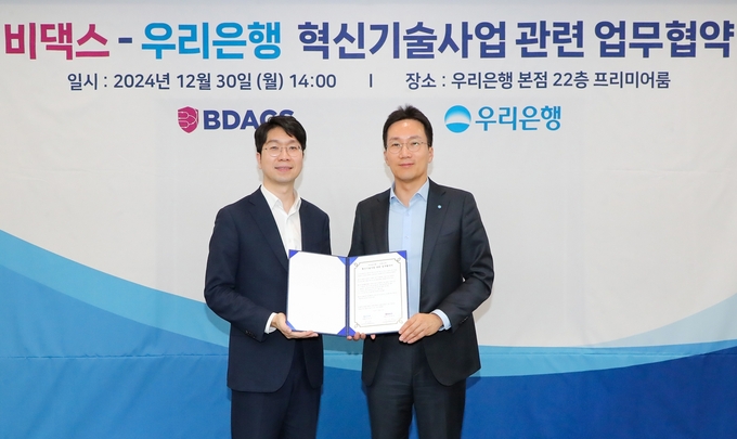 우리은행이 은행 본점에서 비댁스와 혁신기술사업 관련 업무협약(MOU) 체결 후 (왼쪽부터) 류홍열 비댁스 대표, 옥일진 우리은행 디지털전략그룹장이 기념사진을 촬영하고 있다. (사진=우리은행 제공)