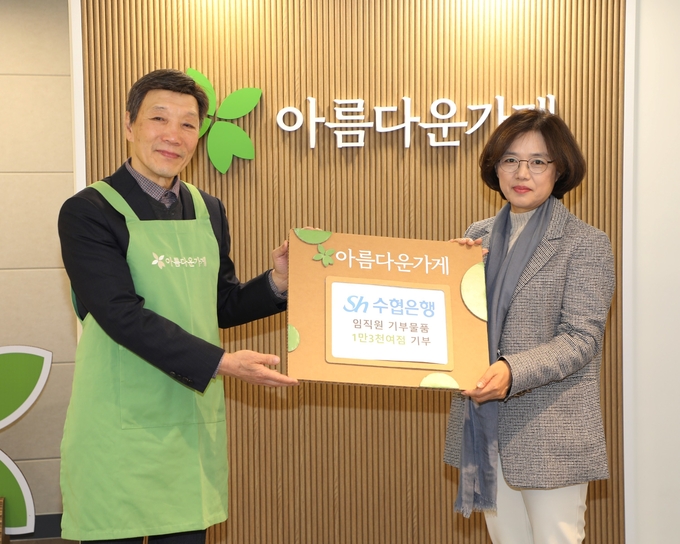 임연숙 수협은행 금융소비자보호본부장(오른쪽)이 박진원 아름다운가게 이사장에게 임직원 물품을 기부하며 기념촬영을 하고 있다. (사진=Sh수협은행 제공)