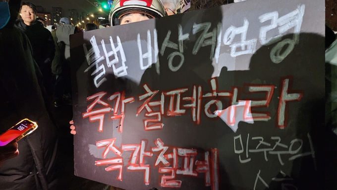  4일 국회의사당 앞에서 비상계엄령을 선포한 윤석열 대통령을 비판하는 피켓을 든 시민의 모습. (사진=박진석 기자)