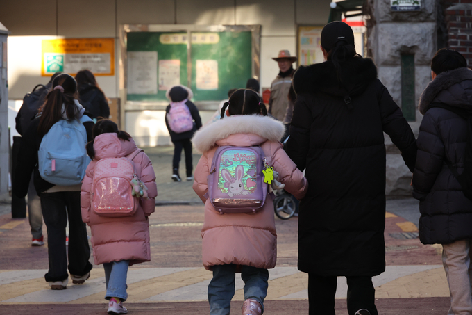 4일 오전 서울 한 초등학교 부근에서 학부모가 자녀들과 교문으로 향하고 있다. 이날 새벽 교육부는 '모든 업무와 학사 일정은 정상운영한다'고 밝혔다. (사진=연합뉴스)