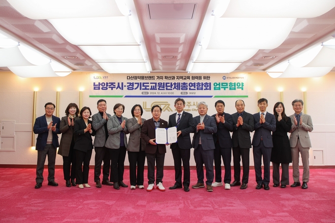 주광덕 남양주시장과 이상호 경기교총 회장이 ‘다산정약용브랜드 교육 업무협약서'를 들어 보이고 있다. (사진=남양주시 제공)