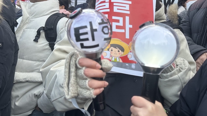 7일 국회 앞 집회에 학생들이 아이돌 응원도구에 '탄핵'을 적어 참여했다. (사진=박민정 기자)