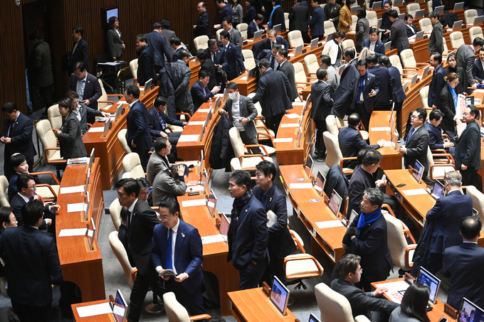 7일 오후 9시 30분께 서울 여의도 국회 본회의장에서 윤석열 대통령 탄핵소추안 표결이 국민의힘 불참에 따른 의결정족수 미달로 인한 투표불성립으로 자동폐기돼 우원식 국회의장이 산회를 선포해 의원들이 본회의장을 빠져나오고 있다