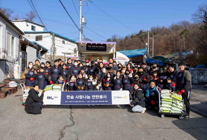 DL이앤씨 임직원 가족들이 서울 노원구 상계동에서 ‘사랑나눔 연탄 봉사활동’을 마친 뒤 기념촬영을 하고 있다. (사진=DL이앤씨 제공)