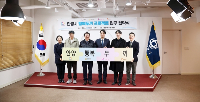 최대호(왼쪽 세 번째) 안양시장과 박준모(네 번째) 안양시의회 의장, 곽동윤(다섯 번째) 시의원이 12일 시청 접견실에서 '행복 두끼 프로젝트' 협약식 후 관계자들과 기념촬영을 하고 있다. (사진=안양시의회 제공)
