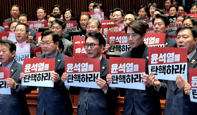 더불어민주당 의원들이 12일 국회 예결위회의장에서 윤석열 대통령의 탄핵을 촉구하는 피켓 퍼포먼스를 진행 중이다. (사진=김한별 기자)