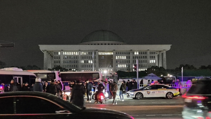 비상계엄이 선포된 지난 3일 자정쯤 서울 여의도 국회의사당 앞에 시민들이 모여들고 있다. (사진=김한별 기자)