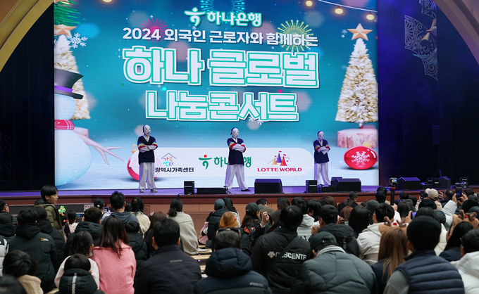 지난 15일 행사에 참여한 외국인근로자 및 다문화가정 구성원들이 우리나라 전통 의상과 탈을 쓰고 국악에 맞춰 비보잉을 하는 '에스플라바(S-FLAVA)'의 댄스 무대를 관람하고 있다. (사진=하나은행 제공)