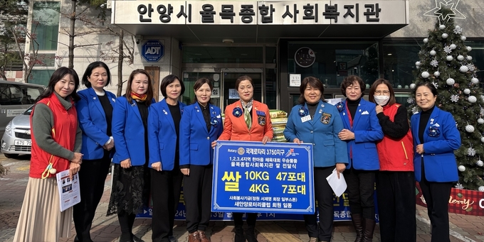 서제영(오른쪽 다섯 번째) 새안양로타리클럽 회장과 회원들이 율목종합사회복지관에 백미를 기탁한 뒤 기념촬영을 하고 있다.(사진=율목복지관 제공)