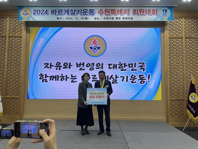 지난 16일 2024 바르게살기 운동 수원특례시 회원대회에서 유재명 바르게살기운동 수원특례시협의회 회장이 수원시 관계자에게 성금을 전달하고 있다. (사진=수원시 제공)