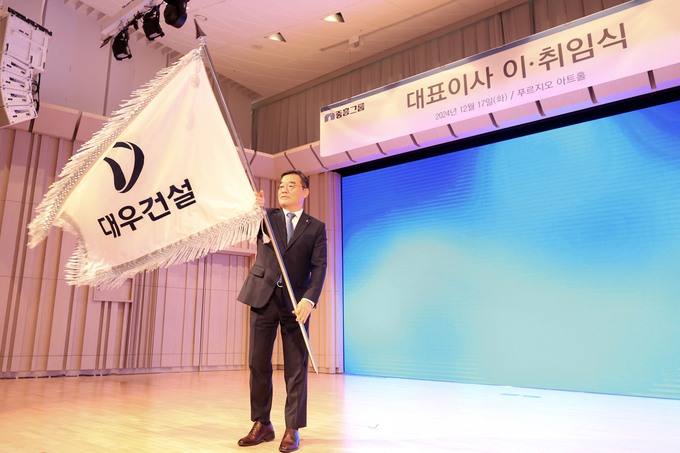 대우건설 푸르지오 아트홀에서 개최된 대표이사 이·취임식에서 김보현 사장이 대우건설 사기를 흔들고 있다. (사진=대우건설 제공)
