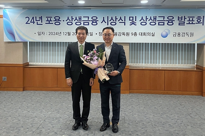 배연수 우리은행 기업그룹 부행장(오른쪽)이 김병칠 금융감독원 부원장과 ‘2024년 포용·상생금융 시상식’에서 기념촬영을 하고 있다. (사진=우리은행 제공)