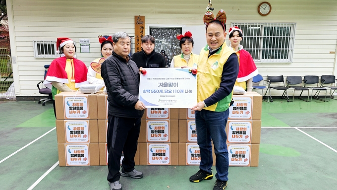 신천지자원봉사단 서울동부지부 단원들이 서울시지체장애인협회 노원구지회 공릉분회에 방한용품을 전달하고 있다. (사진=신천지 제공)