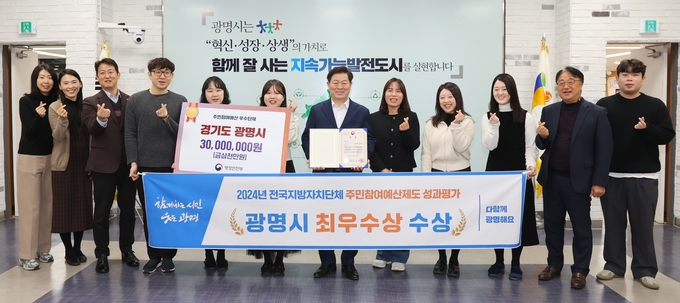 박승원 광명시장(사진 왼쪽에서 일곱 번째)이 '2024년 전국지방자치단체 주민참여예산제도 성과평가' 최우수상 수상을 기념해 예산법무과 직원들과 기념사진을 촬영하고 있다. (사진=광명시 제공)
