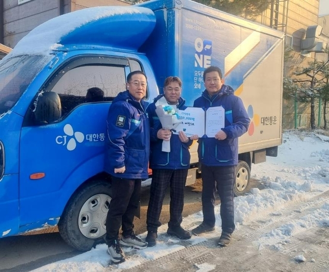 화재 현장을 발견하고 신속한 대처로 피해를 최소화한 배철 씨(가운데)가 포상을 수여받았다. (사진=CJ대한통운 제공)