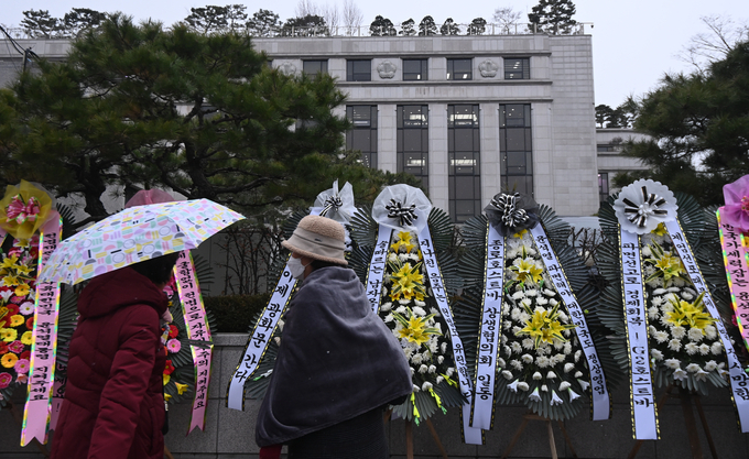 헌법재판소 앞 윤석열 대통령 탄핵 촉구 화환을 시민들이 바라보고 있다. (사진=옥지훈 기자)