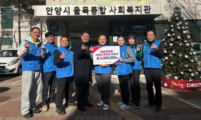 김상목(오른쪽 네 번째) 청솔장학회 회장이 26일 이경석(다섯 번째) 율목종합사회복지관장에게 장학금을 기탁한 뒤 회원들과 기념촬영을 하고 있다. (사진=율목종합복지관 제공)