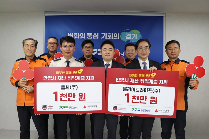 이병권(앞줄 가운데) 올세(주) 대표이사가 26일 이웃돕기 성금을 기탁한 뒤 장재성 안양소방서장(왼쪽) 등과 기념촬영을 하고 있다. (사진=안양소방서 제공)