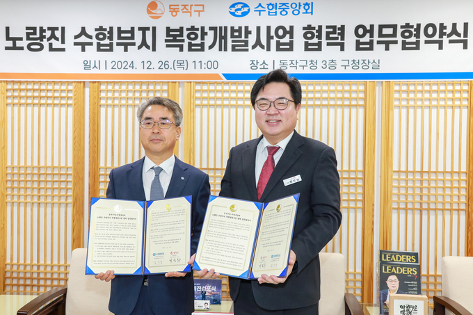 김기성 수협중앙회 지도경제대표이사(왼쪽)와 박일하 동작구청장이 지난 26일 노량진 일대를 서울 랜드마크로 조성하기로 약속하는 ‘노량진 수협부지 복합개발사업 협력’ 업무협약을 체결한 뒤 협약서를 들고 기념촬영을 하고 있다. (사진=수협중앙회 제공)