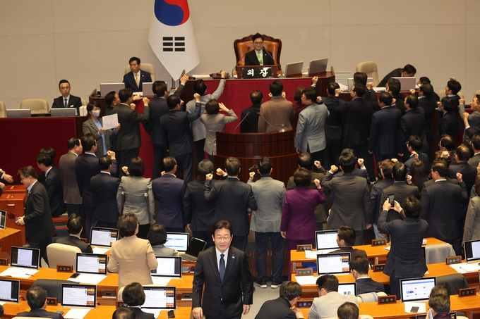 우원식 국회의장이 27일 오후 국회 본회의에서 한덕수 국무총리 탄핵소추안 가결 요건을 '재적 과반'으로 정하자, 이에 대해 국민의힘 의원들이 항의하고 있다. 그 뒤로 투표를 마친 이재명 더불어민주당 대표가 자리로 향하고 있다. (사진=연합뉴스)