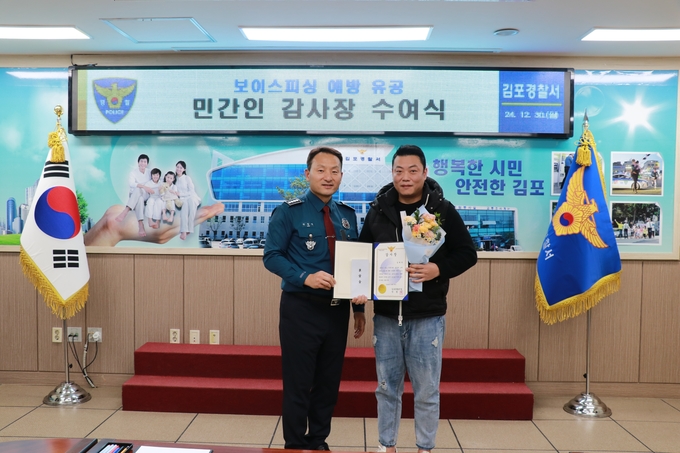 안창익 김포경찰서장이 보이스피싱 현금 인출책 범인을 신고해 범죄예방에 기여한 공로로 시민에게 감사장과 포상을 전달하고 있다. (사진=김포경찰서 제공)