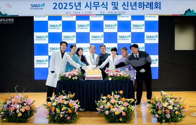 송정한 원장(왼쪽에서 4번째), 박찬경 노조위원장(왼쪽에서 5번째), 출생연도가 뱀띠인 직종별 직원 대표가 커팅식을 진행하고 있다. (사진=분당서울대병원 제공)