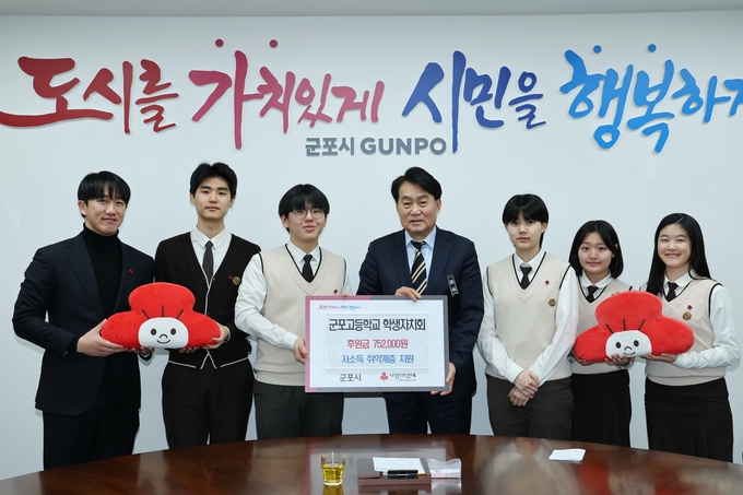 군포고등학교 학생자치회 학생들이 하은호 군포시장(사진 가운데)에게 ‘교복 물려주기’ 행사에서 발생한 수익금 75만원을 기탁하고 있다.(사진=군포시 제공)