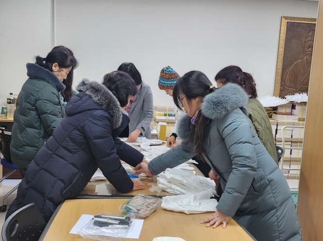 파주시 운정1동은 출생신고를 위채 찾은 10가정에 배냇저고리를 전달했다, 사진은 파주문화원 손길 동아리 회원들이 배냇저고리를 기탁하위 위해 정리를 하고 있다. (사진=운정1동 행정복지센터)