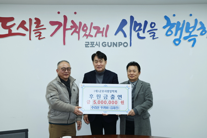 군포 수리산두꺼비 김재진 대표가 군포사랑장학회에 5백만원을 기탁하고 하은호(가운데) 군포시장과 기념촬영을 하고 있다. (사진=군포시 제공)