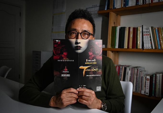 지난 12월 2일 박현준 '어게인 2024 투란도트' 예술총감독이 투란도트 공주 얼굴이 그려진 포스터에 얼굴을 갖다 대고 있다. 박 감독은 지난 2003년 한일 월드컵 1주년을 기념하기 위해 상암 월드컵 경기장 절반을 무대로 만들어 열렸던 투란도트 공연 이후 21년 만에 총 제작비 약 200억원을 들여 초대형 오페라를 다시 재현하겠다고 포부를 밝혔다. (사진=옥지훈 기자)