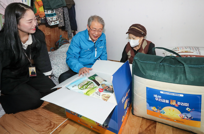 임종룡 우리금융그룹 회장이 어르신 가정에 방문해 지원 물품을 설명하고 있다. (사진=우리금융그룹 제공)